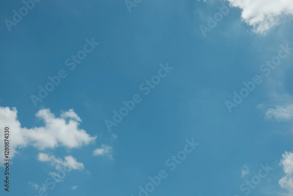 Fototapeta A simple, minimalistic scene of a lone white cloud floating in a vast blue sky, creating a clean and serene atmosphere