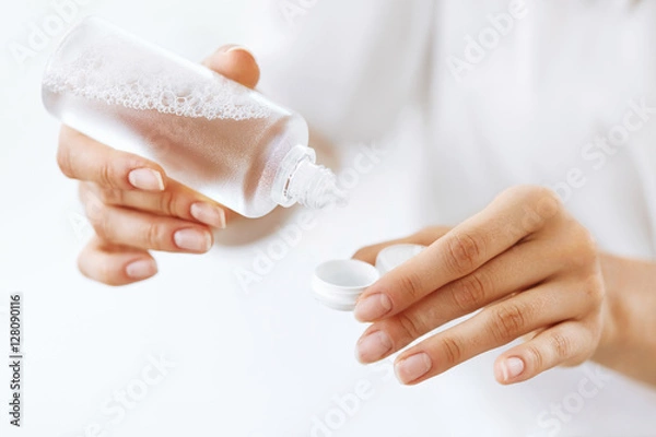 Fototapeta Kobieta Ręce Wprowadzenie Płynu Z Butelki Do Pudełka Obiektywu