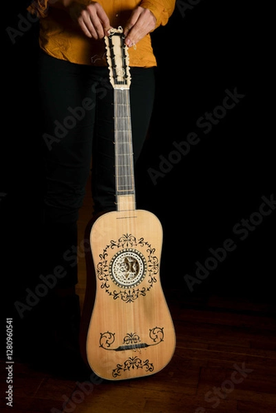 Fototapeta Vertical photo of a baroque guitar isolated on black background