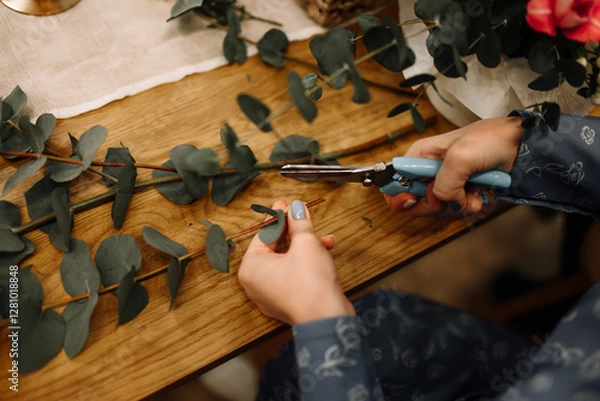 Fototapeta Close-up of florist's hands cutting flowers with secateurs