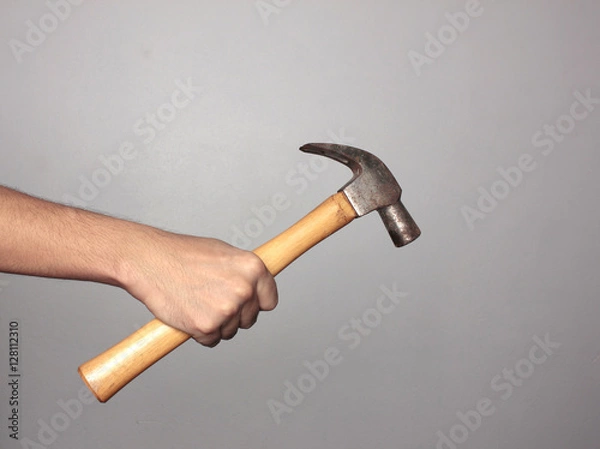 Obraz Man holding hammer on gray background