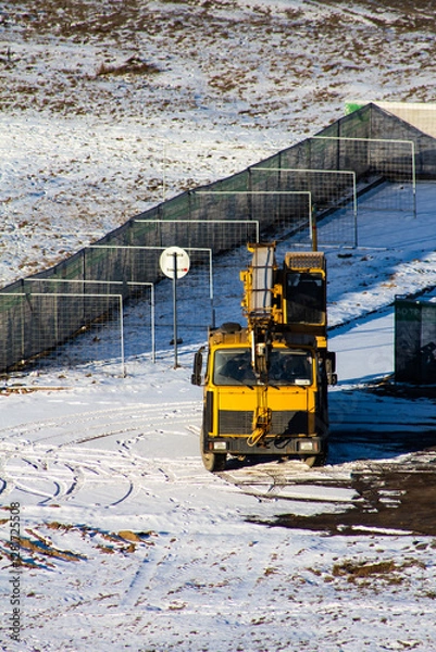Obraz yellow crane in the winter on the construction site, clean the snow in the fog and the sun
