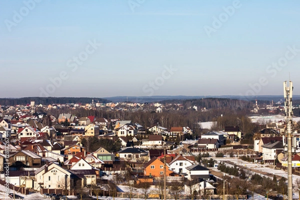 Obraz winter photography of a snowy suburban neighborhood, showcasing snow-covered houses and trees in a peaceful setting, perfect for seasonal marketing and landscape visuals.