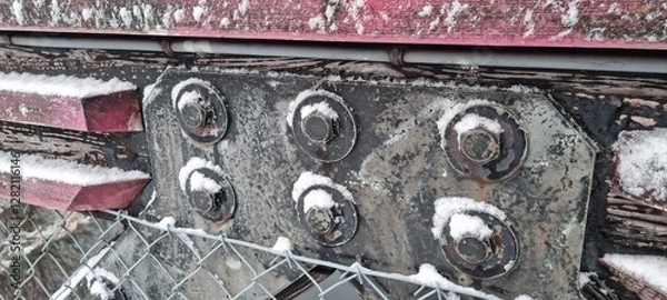 Fototapeta Metal bolts on foot bridge in winter with cold rime closeup