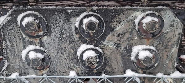 Fototapeta Metal bolts on foot bridge in winter with cold rime closeup