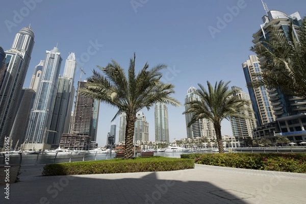Fototapeta Modern corporate city. Skyscrapers wide angle view from the bottom. Business and finance theme. Dubai city main highway. Wide angle shot. Place for text.