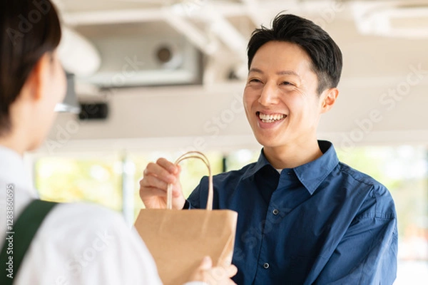 Obraz テイクアウト商品を受け取るミドルの男性