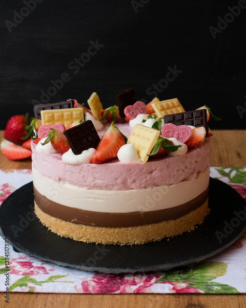Fototapeta Strawberry, vanilla and chocolate cake decorated with chocolates and strawberries. Neapolitan cake