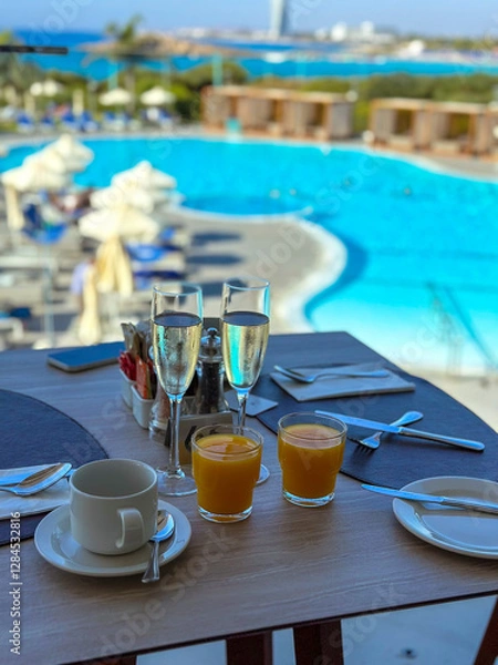 Fototapeta breakfast in the restaurant near the blue pool in the hotel with fresh juice and prosecco .