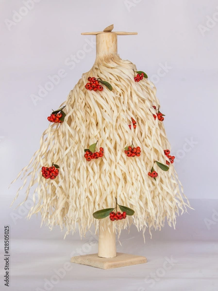 Obraz  Christmas tree made of wood shavings with red berries 
