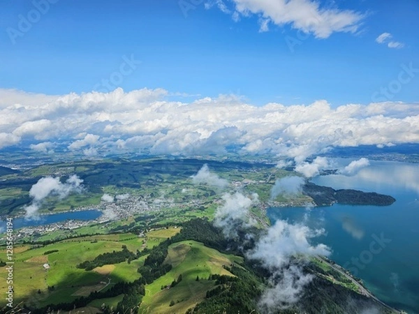 Fototapeta A stunning summer view from Mount Rigi, often referred to as the "Queen of the Mountains," offering panoramic vistas of the Swiss Alps and surrounding lakes. This image captures the lush green meadows