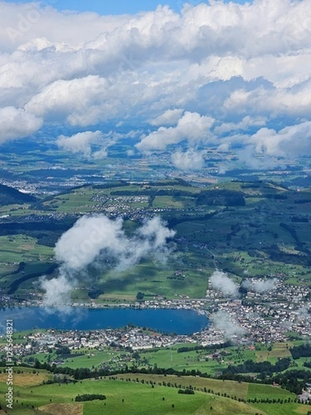 Fototapeta A stunning summer view from Mount Rigi, often referred to as the "Queen of the Mountains," offering panoramic vistas of the Swiss Alps and surrounding lakes. This image captures the lush green meadows