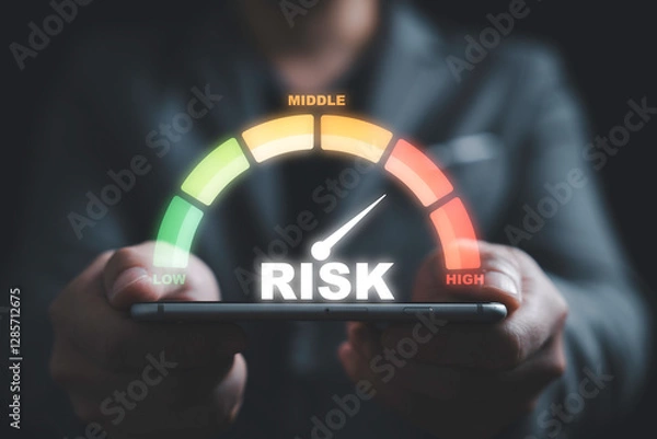 Fototapeta Businessman holding smartphone with  risk level indicator rating since low to high for Risk management and assessment concept.