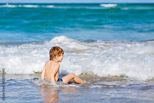 Obraz little blond kid boy having fun on ocean beach in Florida