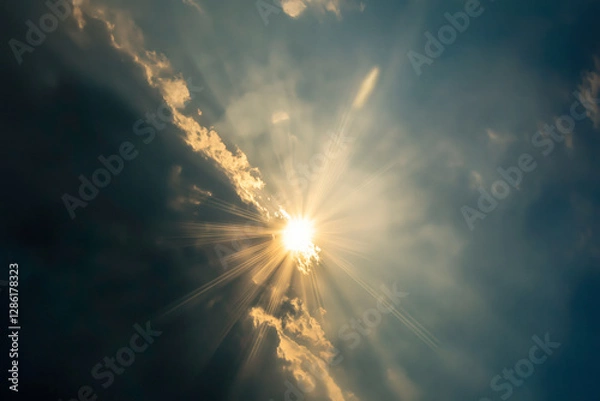 Obraz Sunlight breaking through dark clouds, casting radiant beams of light, symbolizing divine presence and hope