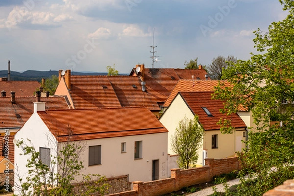 Obraz Traditional red-roof houses in Mikulov, Czech Republic. A scenic view of charming houses with red-tiled roofs in Mikulov, Czech Republic, surrounded by greenery and historic architecture