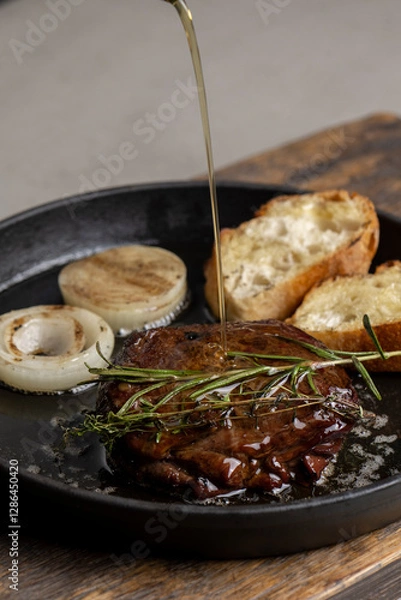 Fototapeta Pan-fried steak with toast and rosemary, drizzled with olive oil