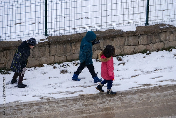 Fototapeta It snowed and the little friend kids are walking on the snow,