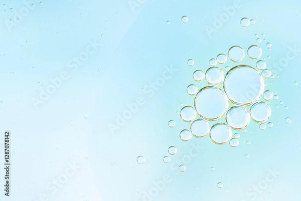 Fototapeta Transparent water bubbles rising in a soft blue liquid background. Refreshing, clean photo perfect for themes of purity, hydration, and freshness. Cosmetic advertising and scientific illustration. 