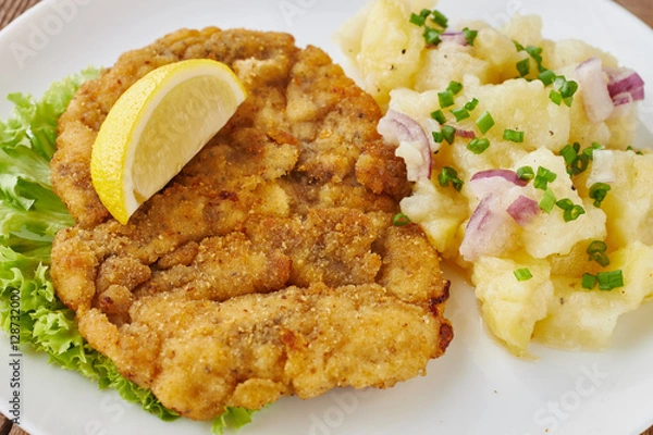 Fototapeta Weiner schnitzel with potato salad on a wooden background