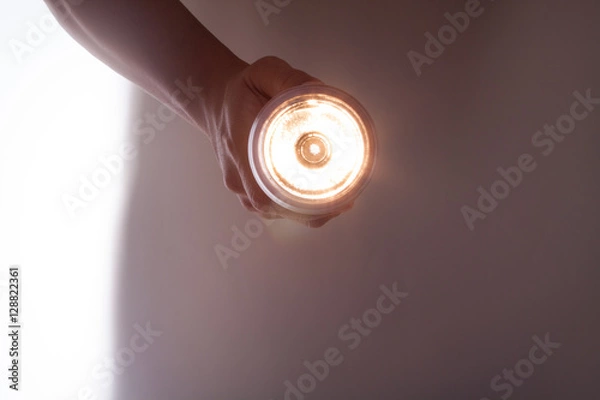 Obraz 懐中電灯を手に持って照らす