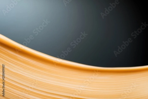 Fototapeta Soft golden curve contrasts against deep background, creating se