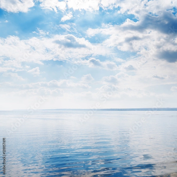 Fototapeta river closeup and clouds over it
