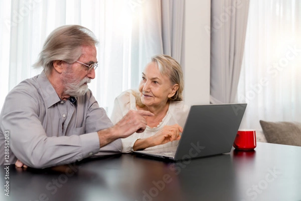 Obraz Happy Caucasian 70s mature couple using laptop at home. Old people using computer at home. Senior man and woman surfing the web on a wireless laptop connection. Modern retired lifestyle people.