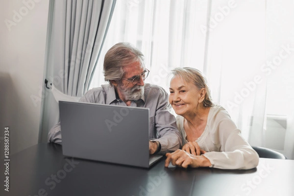 Obraz Happy Caucasian 70s mature couple using laptop at home. Old people using computer at home. Senior man and woman surfing the web on a wireless laptop connection. Modern retired lifestyle people.