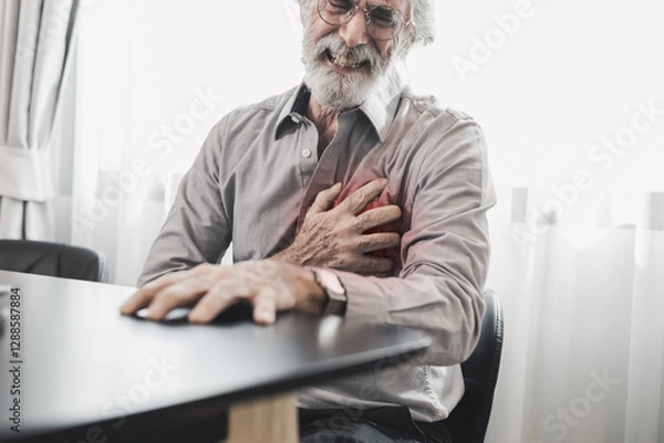 Obraz Senior man in spectacles presses hand to chest has heart attack suffers from unbearable chest pain closes eyes wears glasses sitting on the chair in living room. People age and problems with health.