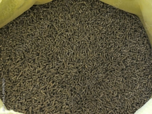 Fototapeta bag surrounded by pressed pellets of farm poultry feed, top view, example of factory-produced combined balanced feed for farm poultry