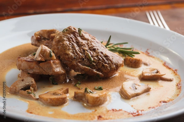 Obraz Concept: restaurant menus, healthy eating, homemade, gourmands, gluttony. White plate of pork medallions with mushroom sauce on weathered wooden table.