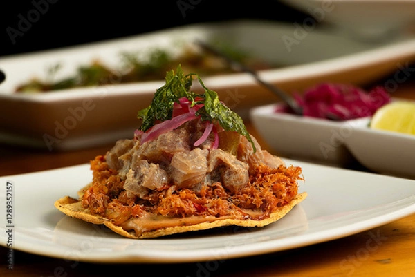 Fototapeta Marlin's tostada with some tuna fish on top, some cilantro, and another food in the back