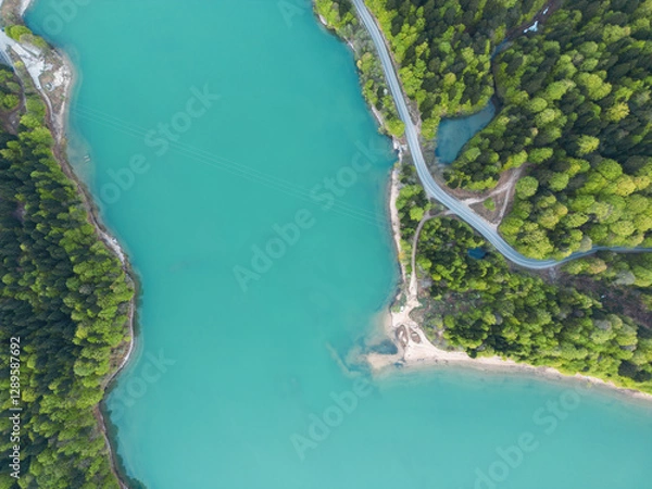 Obraz car drives along a road along a mountain lake, forest and sandy cape,aerial view
