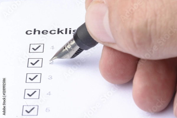 Obraz Businessman checking mark on checklist with marker over white