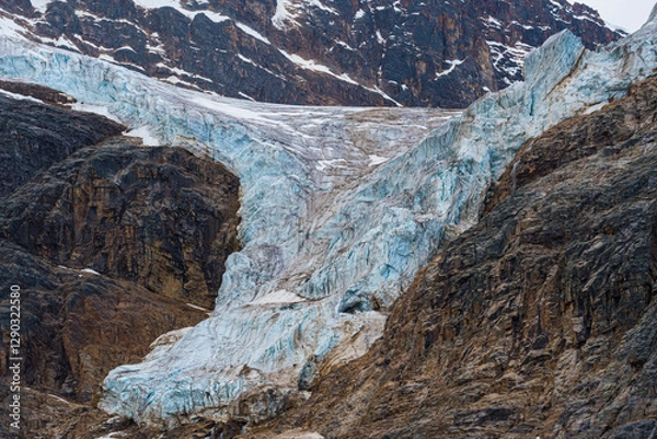 Fototapeta A mesmerizing view of a glacier slowly melting in a rugged landscape, highlighting the effects of climate change and nature's power in stunning detail.