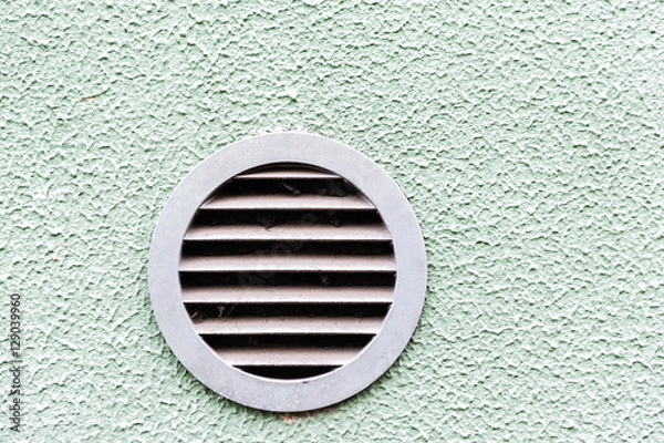Fototapeta circular plastic air vent in white wall ventilation grille