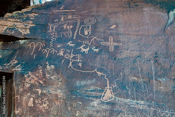 Fototapeta An ancient rock surface adorned with petroglyphs, depicting a rich history and cultural significance through intricate carvings and symbols.