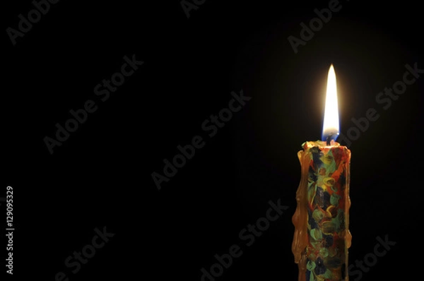 Fototapeta Candle on a black background