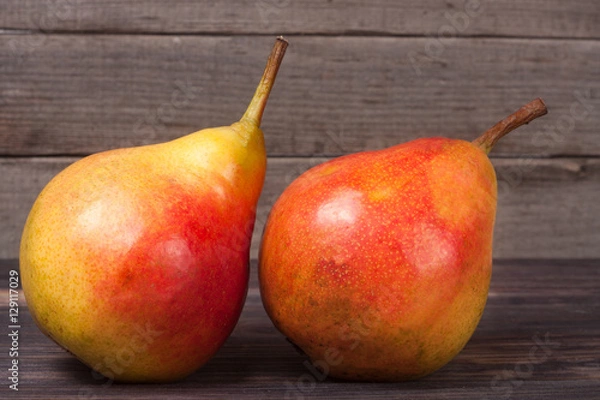Fototapeta two pears on a dark wooden background