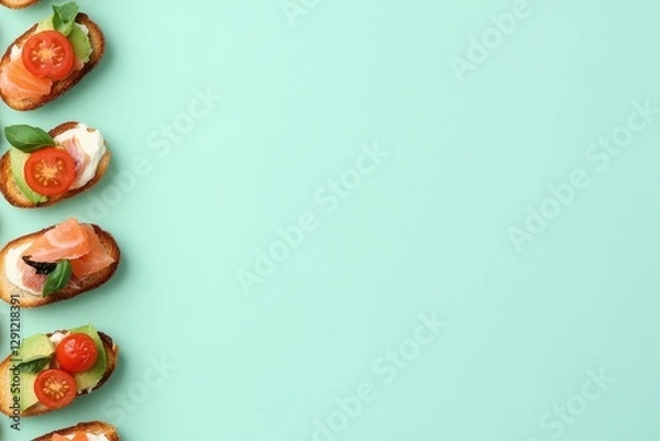 Fototapeta Colorful canapés arranged neatly on mint green background highli
