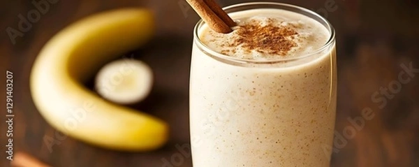 Obraz Creamy and nutritious banana and almond butter smoothie served in a tall glass garnished with a cinnamon stick for added flavor and aroma  A delicious and healthy beverage perfect for breakfast snack
