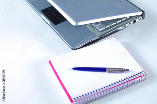 Fototapeta Office table with blank notepad and laptop