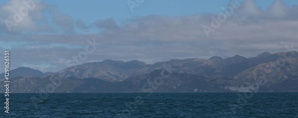 Obraz Delightful sea landscape with blue surface of the water, magic feather clouds on the sky over mountain in Kaikoura,New Zealand