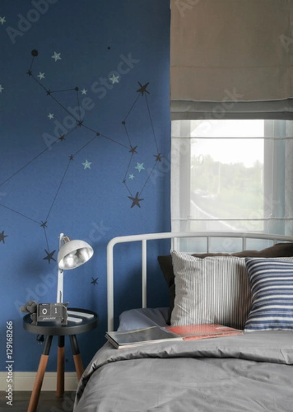 Fototapeta Beige and striped pillow on modern style bed setting and the blue wall bedroom