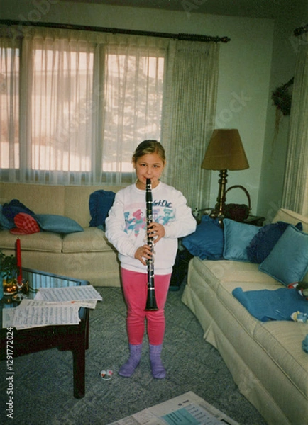 Fototapeta Circa 1995 - 10 year old girl playing the clarinet in a living room. Image is a vintage scan and may have imperfections