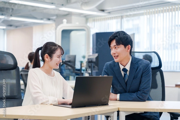 Fototapeta 先輩社員から業務を教えてもらう新人の女性