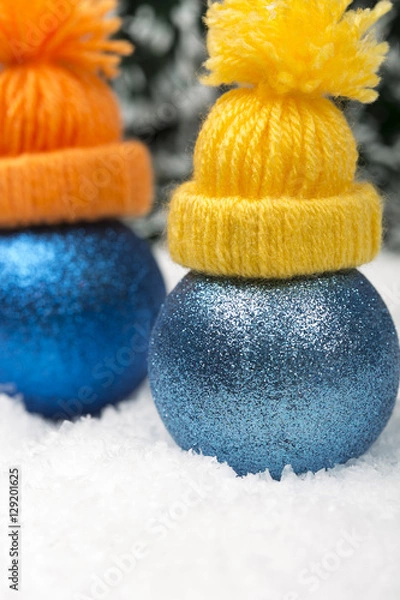 Fototapeta Funny Christmas background with a blue ornament with winter cap, golden gift box, Angels, berries and fir in snow on forest backround