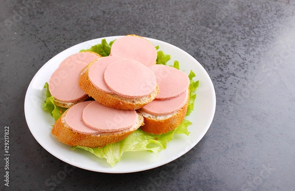 Fototapeta sandwiches with doctoral sausage in a white plate on a white background