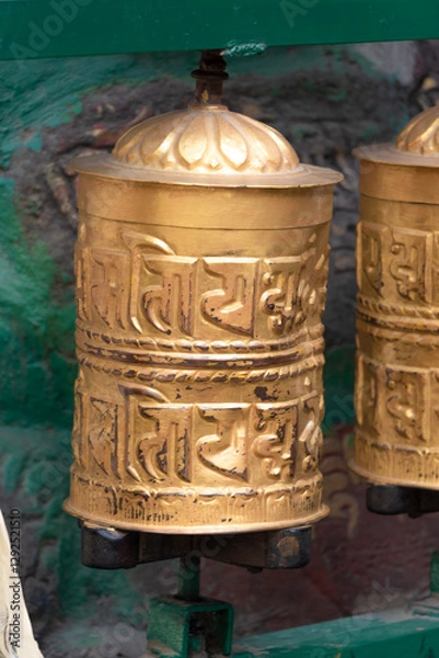 Fototapeta Prayer wheels is spun by devotees to aid for meditation and accumulating wisdom, good karma and putting negative energy aside